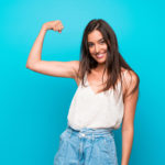 Young woman over isolated blue background doing strong gesture Young woman over isolated blue background doing strong gesture